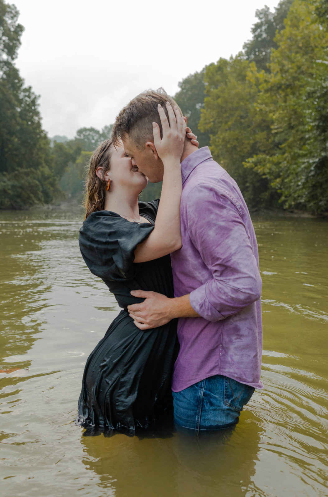 Couple kissing in the river during the summer.