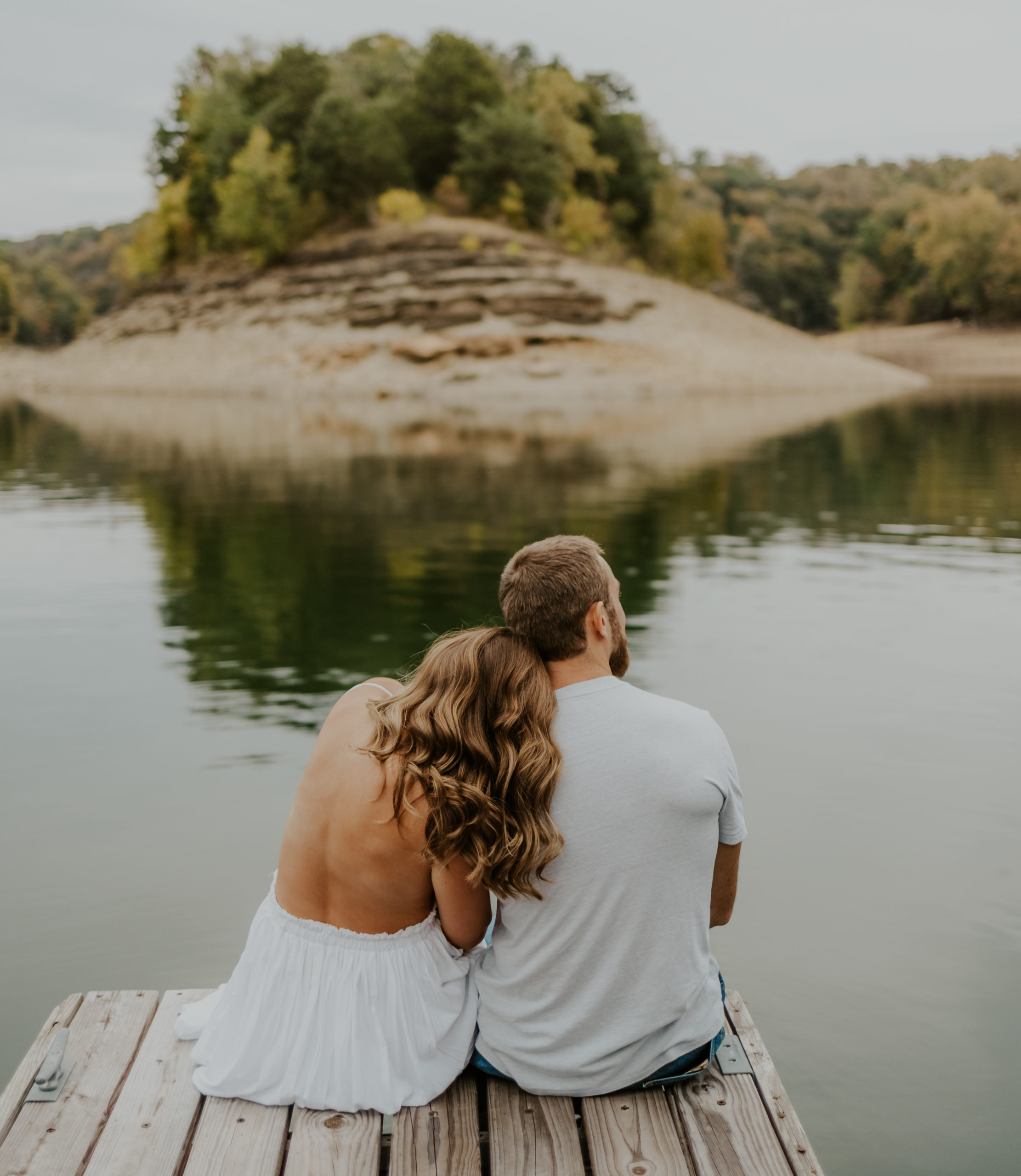 Lake cumberland couple posed on a dock overlooking the water in Kentucky.