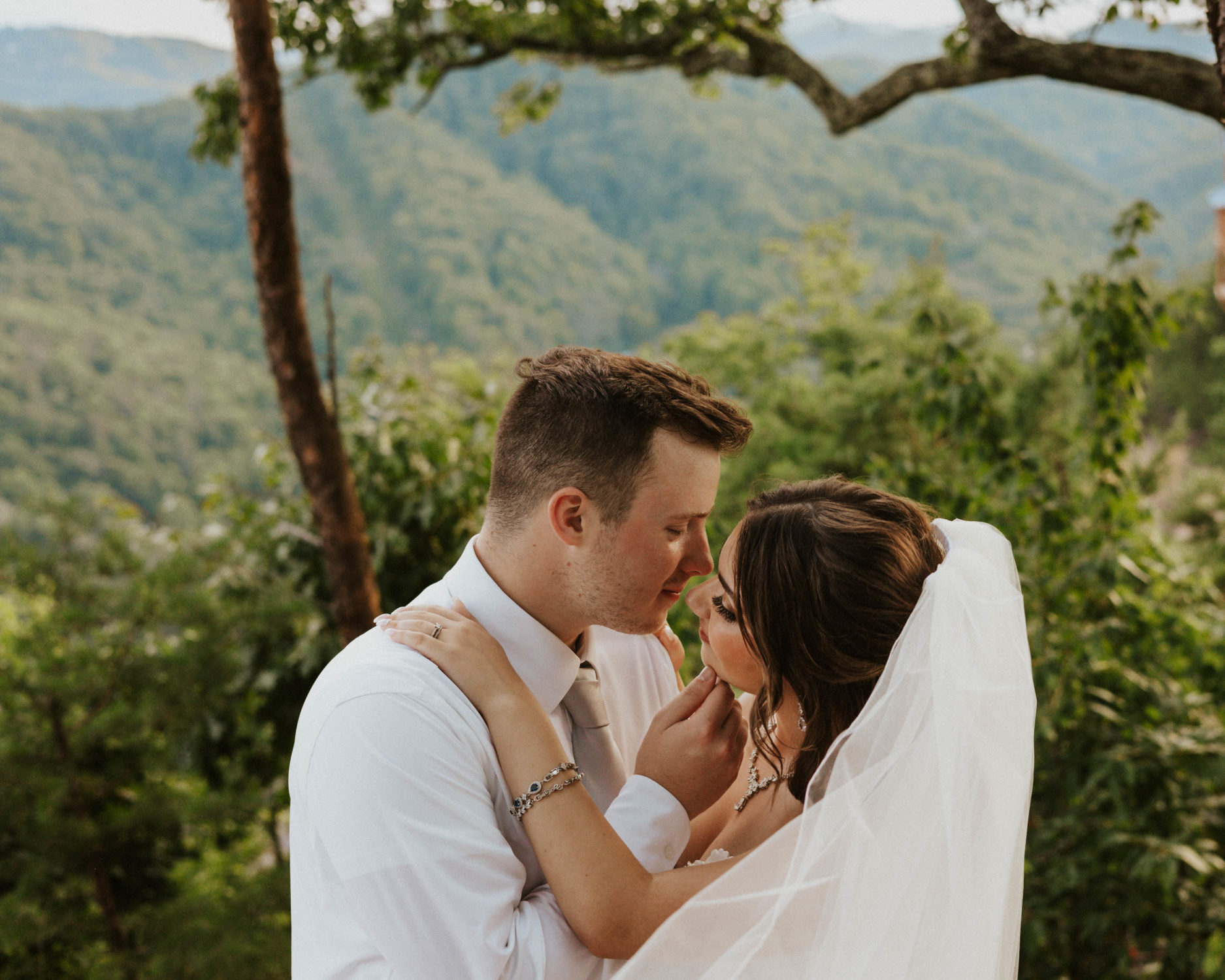 A groom pulls his bride in for a kiss during their elopement in the Great Smoky Mountains.