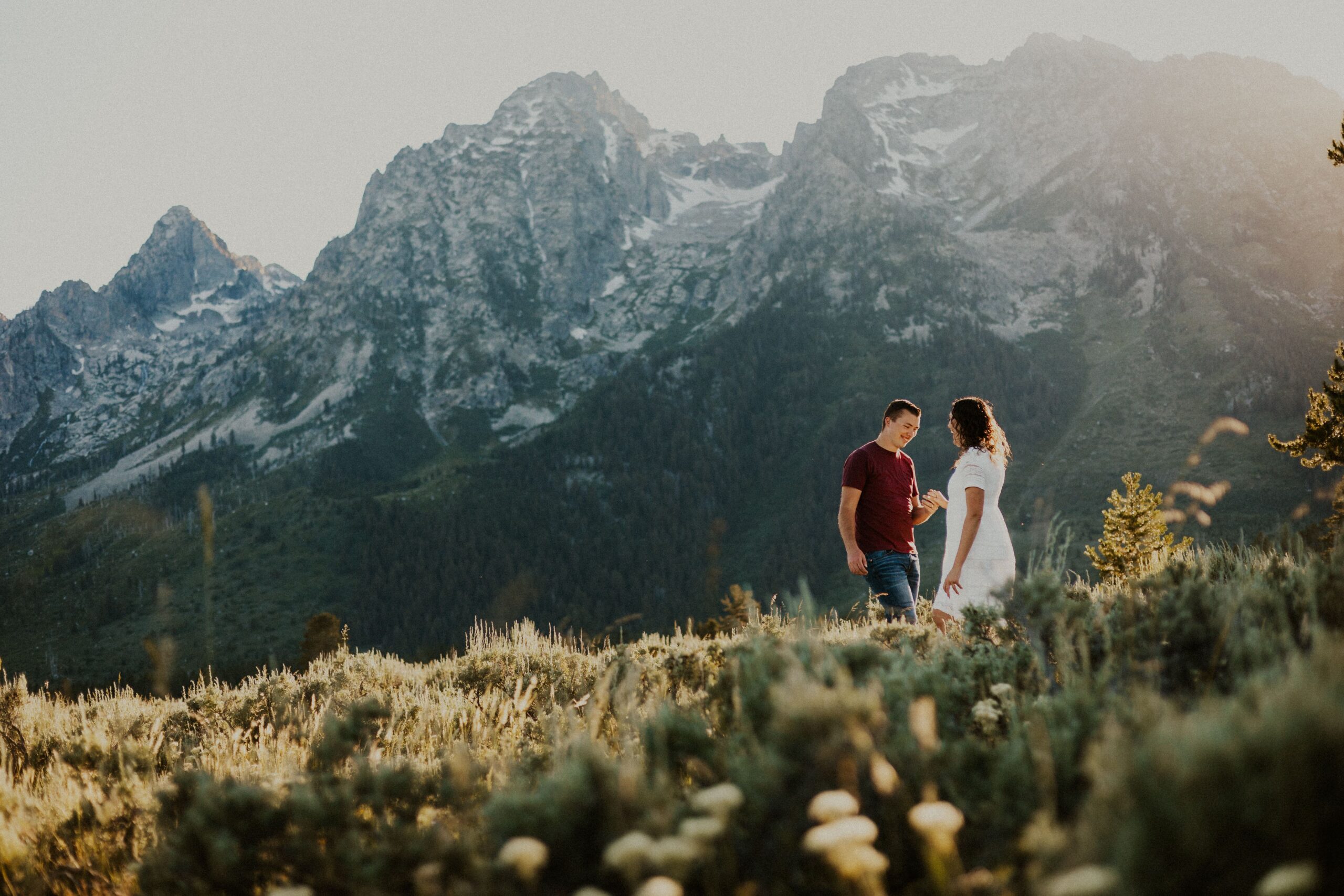 A couple holds hands while taking their engagement photos in Grand Teton National Park