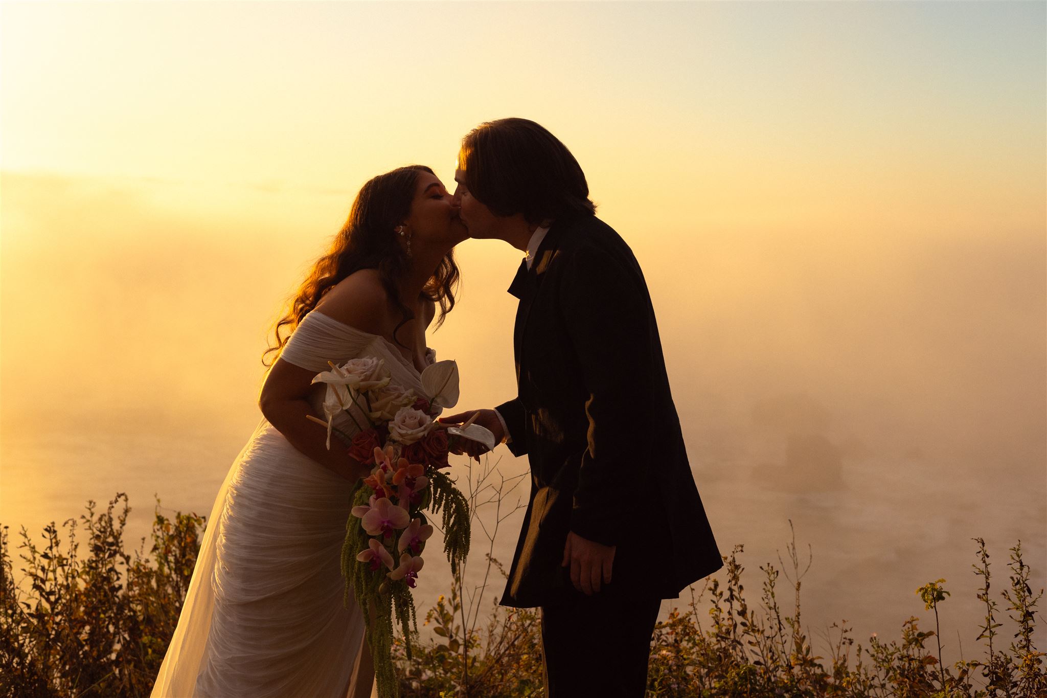 A couple kisses at their wedding in Big Sur, California.